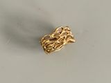 une bague en or munie d'une chaîne, posée sur une table