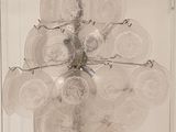 a glass chandelier with a bunch of plates hanging from it