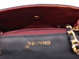 the purse is black and red with a gold chain around it