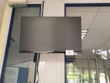 a flat screen tv hanging from the ceiling in a room