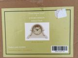 a box with a clock inside of it on a tile floor