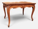 an old wooden table with a carved top and legs