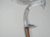a metal knife with a wooden handle hanging on a wall