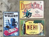 Trois enseignes publicitaires vintage différentes sont exposées sur une surface en béton