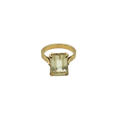 a close up of a gold ring with an emerald stone