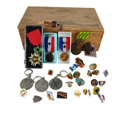 une boîte en bois contenant un tas de médailles et d'autres objets
