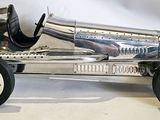 a silver toy car that is sitting on a white surface