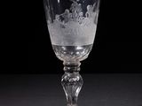 a glass with a design on it sitting on a table