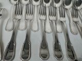 a lot of silver spoons and forks on the table