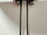 pair of metal spoons on a white surface with a white background