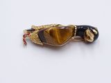 tiger ' s eye brooch with gold and black accents on a white background