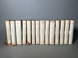 plusieurs livres sont alignés sur une surface grise