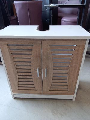 a wooden cabinet with two doors and a wine glass on top