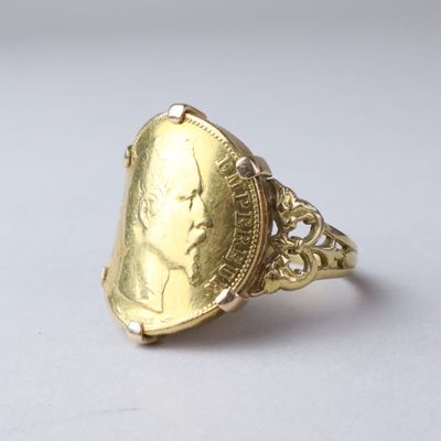 an image of a gold ring with a coin in the middle