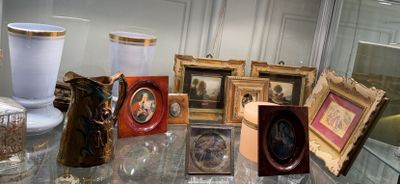 a table with a lot of picture frames and vases on it