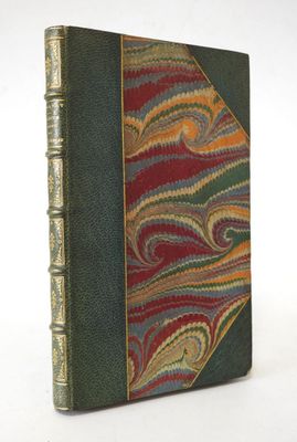 un vieux livre à la couverture verte, orné d'un motif rouge, jaune et vert