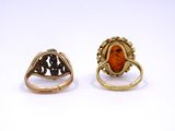 two gold rings with an orange stone in the middle