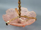 underside view of a pink glass umbrella with a brass handle