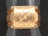 une image représentant une bague en or sur laquelle figure la lettre « m »