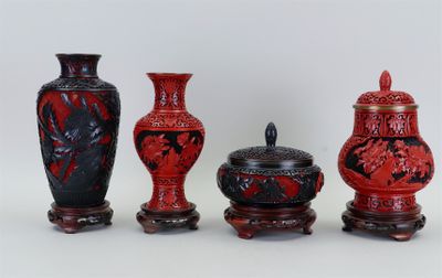 trois vases rouges posés les uns à côté des autres sur une table