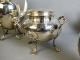 three silver teapots sitting next to each other on a table
