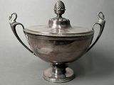 a silver bowl with a bird on top of it