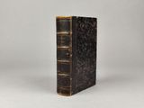 un vieux livre posé sur une surface blanche