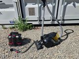 un petit appareil posé par terre à côté d'un conteneur