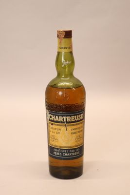 une vieille bouteille de whisky Chartreuse posée sur une surface blanche