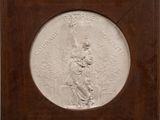a white relief of a woman holding a child in a wooden frame