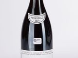 une bouteille de vin rouge posée sur une table blanche