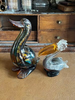 two figurines of a pelican and a glass pelican