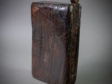 un vieux livre en bois posé sur une surface grise