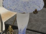 une lampe bleue et blanche posée sur une table à côté d'un ordinateur portable