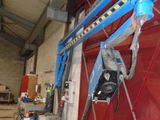 a blue crane that is attached to a red wall