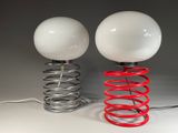 two lamps that are on top of a red spring