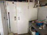un réfrigérateur blanc dans une petite cuisine, à côté d'un évier