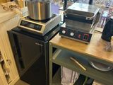 a kitchen with a stove and a counter with pots and pans on it