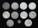 Plusieurs pièces d'argent sont disposées en cercle sur une surface noire