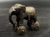statue of an elephant on wheels on a black surface