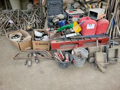 a pile of junk sitting on the ground next to a pile of tools