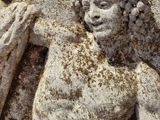 a statue of a man holding a sword on a stone wall