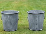 deux poubelles en métal posées sur l'herbe dans le jardin