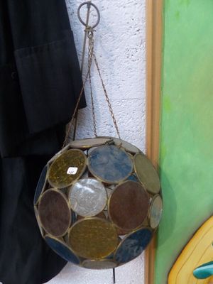 une boule de verre accrochée au mur à côté d'une planche de surf