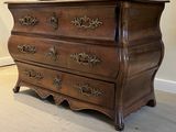 une commode en bois posée dans un coin de la pièce