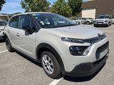 La Citroën blanche est garée sur un parking avec d'autres voitures
