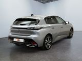 the rear end of a silver car in a white room