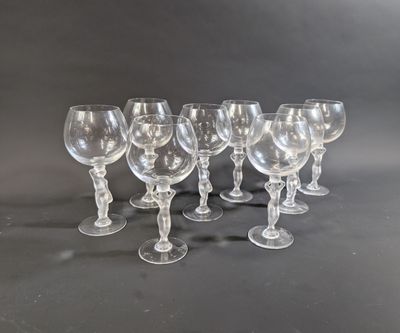 six clear wine glasses lined up in a row on a black surface