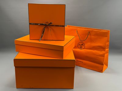 Trois boîtes orange sont empilées les unes sur les autres sur une table