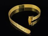 a close up of a gold bracelet on a black surface